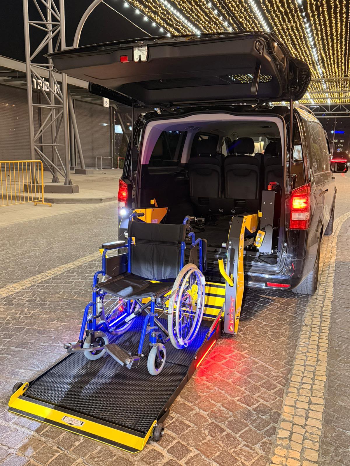 Wheelchair standing on the electric lift platform of a Meet Transfer accessible vehicle